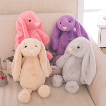 Load image into Gallery viewer, Four plush bunny toys in pink, purple, beige, and gray sitting on a couch.
