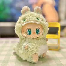 Load image into Gallery viewer, Labubu dressed in a fluffy mint green dinosaur outfit with adorable details like small ears, sharp teeth, and a cozy hood, sitting on a table.