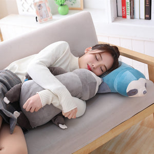 girl lying on blue sloth plushie while hugging cute grey sloth plushie