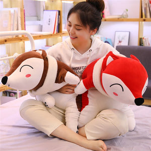 girl hugging brown fox plushie and red fox plushie